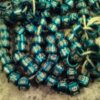 A pile of blue beads with the letters n and e on them.