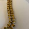 A long necklace of yellow and white beads.