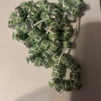 A bunch of green beads are laying on the table|A long necklace of yellow and white beads.