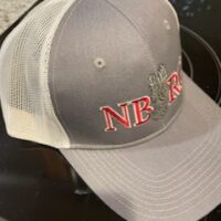 A grey and white hat with the letters nb r on it.|A gray and white hat with the words nbrc on it.