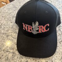A black hat with the letters nbrc on it|A black hat sitting on top of a counter.