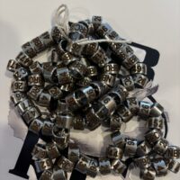 ||A string of silver beads on top of a table.