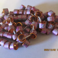 A pile of purple beads sitting on top of a table.