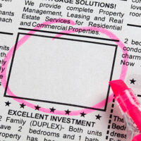 A pink marker is stuck in the side of a newspaper.|